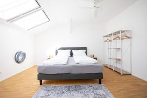 um quarto com uma cama num quarto branco em Ko-Living - Captain's Suite - Altstadt - mit Küche, Smart TV & Balkon - 6P em Halle an der Saale