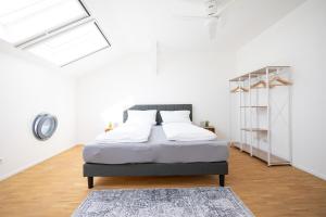 1 dormitorio con 1 cama en una habitación blanca en Ko-Living - Captain's Suite - Altstadt - mit Küche, Smart TV & Balkon - 6P, en Halle an der Saale
