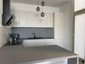 a white kitchen with a sink and a counter at Green Coast 136 in Dhërmi +28 photos
