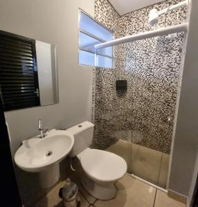 W łazience znajduje się toaleta, umywalka i prysznic. w obiekcie Hotel Pousadas Club w mieście Sorocaba