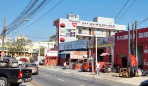 索羅卡巴的住宿－Hotel Pousadas Club，一条繁忙的城市街道,汽车停在大楼前