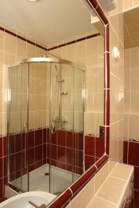 a shower with a glass door in a bathroom at Komfort Hotel Platan in Harkány