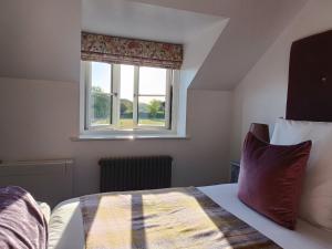 Schlafzimmer mit einem Bett und einem Fenster in der Unterkunft Keepers Retreat in Rowlands Castle