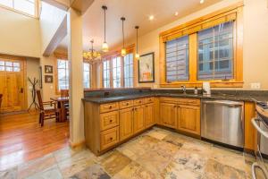 a large kitchen with wooden cabinets and a stainless steel dishwasher at Cabin in the Heart of Town - Big Sky in Big Sky