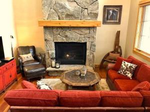 a living room with a couch and a fireplace at Cabin in the Heart of Town - Big Sky in Big Sky