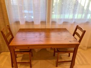 a wooden table with two chairs in front of a window at Apartment Deluxe with Garden Rapperswil-Jona in Jona