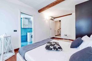 1 Schlafzimmer mit einem großen weißen Bett und einem Badezimmer in der Unterkunft Mazzini Deluxe Apartment in Ferrara