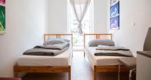 two twin beds in a room with a window at Meisterhaus Apartments in Glauchau