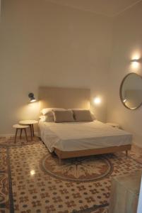 una camera con un grande letto e uno specchio di Palazzo Del Cavaliere a Gallipoli