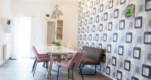 a dining room with a table and pink chairs at Meisterhaus Apartments in Glauchau