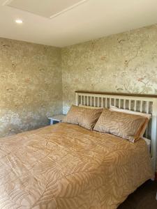 a bedroom with a large bed with floral wallpaper at Rose Creek Cottage in Cromwell