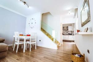 une salle à manger blanche avec une table et un escalier dans l'établissement Rentaliday Estrella Marazul, à Las Galletas