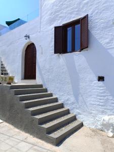 uma escada que leva a um edifício com uma porta e uma janela em Lindos Villa Euphoria em Lindos