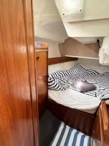una cama pequeña en la parte trasera de un barco en Matahari - Bateau cocooning à quai en Les Sables-dʼOlonne