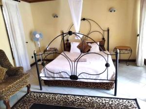 a bedroom with a bed and a chair at Copperbelt Executive Accommodation Ndola, Zambia in Ndola