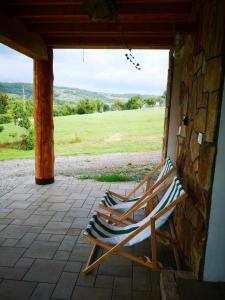 a rocking chair sitting on a porch with a stone wall at Domek "PRZYBYSZÓWKA" Bieszczady in Mchawa