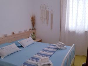 Un dormitorio con una cama azul con toallas. en Appartamento Verde mare, en Torre Pali