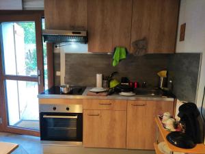 a small kitchen with a stove and a sink at Maisonette individuelle a roquefeuil dans les Pyrénées audoises in Roquefeuil