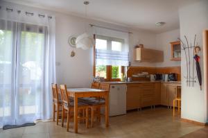 a kitchen with a wooden table and a table and chairs at bliźniak-apartamenty in Rowy