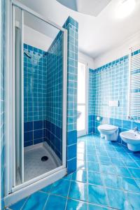 ein blau gefliestes Bad mit einer Dusche und einem WC in der Unterkunft Mazzini Deluxe Apartment in Ferrara