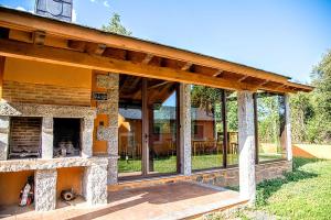 a house with a stone fireplace in the yard at Lagunas de Sanabria in Trefacio