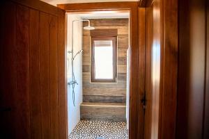 uma casa de banho com uma cabina de duche ao nível do chão ao lado de uma janela em Lagunas de Sanabria em Trefacio