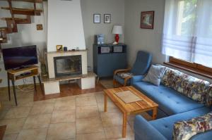 bliźniak-apartamenty في روفي: غرفة معيشة مع أريكة زرقاء ومدفأة