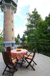 a table and chairs with a lighthouse in the background at Apartments Boltez in Kranj
