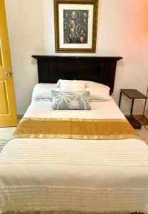 a large bed with a wooden headboard in a bedroom at Great Savannah Guesthouse in Sabana Grande