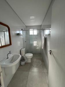 La salle de bains est pourvue de toilettes, d'une baignoire et d'un lavabo. dans l'établissement Pousada Recanto do Neca, à Florianópolis