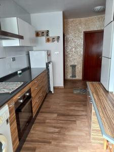 a kitchen with black counter tops and wooden floors at Apartamento turístico en el centro de Benavente in Benavente