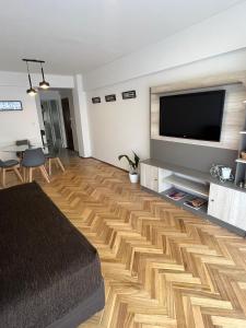 a living room with a television and a wooden floor at Departamento luminoso en Rosario centro in Rosario