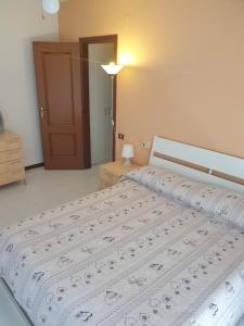 een slaapkamer met een groot bed en een wit dekbed bij Appartamento ALICE (CISANELLO-PISA) in Pisa