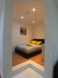 Un dormitorio con una cama con almohadas amarillas. en City Sparrow Pad 6 en Londres