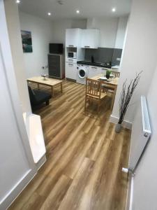 a living room with a table and a kitchen at City Sparrow Pad 6 in London