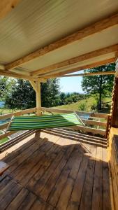 un portico in legno con tenda da sole su un ponte in legno di Cabana Himalaya Lodge cu ciubăr din inima munților Apuseni- masivul Buces -Vulcan a Buceş-Vulcan