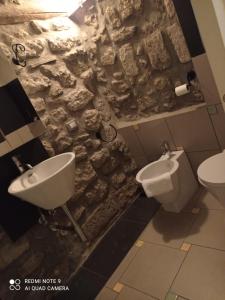 a stone bathroom with a sink and a toilet at La Torre in Vitorchiano