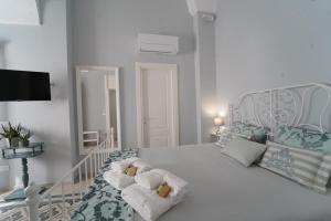 a white bedroom with a bed with towels on it at B&B Puglia d'aMare in Lizzano