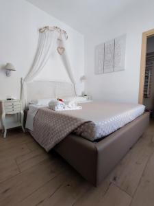 Dormitorio blanco con cama con dosel en BeB Pignatelli Affittacamere, en Matera