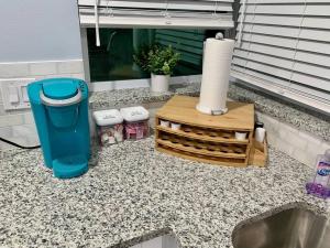 a counter top with a roll of paper towels and a trash can at Home in West Palm Beach with Heated Pool in West Palm Beach