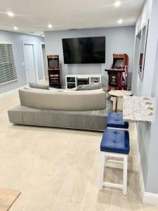 sala de estar con sofá y TV de pantalla plana en Home in West Palm Beach with Heated Pool, en West Palm Beach