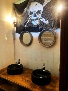 two black sinks in a bathroom with two mirrors at Auberge K-WAN Hostel in Deshaies