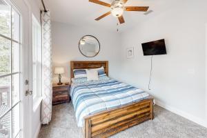 a bedroom with a bed and a ceiling fan at Cast a Waves in Panama City Beach