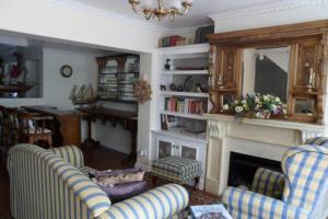 a living room with two chairs and a fireplace at Birkenhead Manor in Bloubergstrand