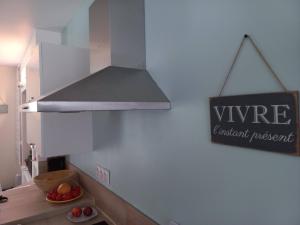 a kitchen with a sign that says vine and a counter top at Le secret de la Glycine in Lillebonne