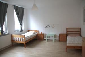 1 Schlafzimmer mit 2 Betten, einem Tisch und 2 Fenstern in der Unterkunft Ferienwohnung Philippstraße 35 in Meerane