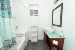 a white bathroom with a sink and a mirror at Bike to Beach-Spacious With Patio BBQ & Game Room (Pet-Friendly) in Hallandale Beach +14 photos