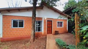 una pequeña casa de ladrillo con puerta roja en Voces De La Selva Misionera en Puerto Iguazú