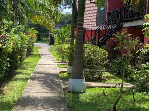 a sidewalk next to a house with a palm tree at Secret Cabins at Firefly Beach Cottage in Negril