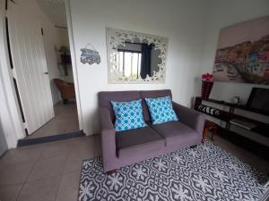a living room with a purple couch and a rug at Ocean Rush Dolphin in Zinkwazi Beach